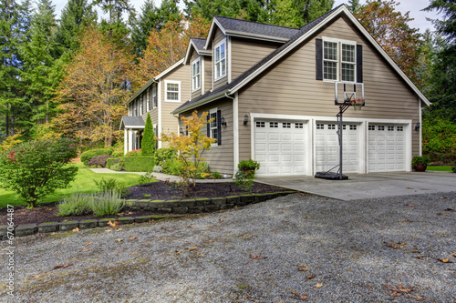 House exterior. View of three car garage with driveway and baske © Iriana Shiyan