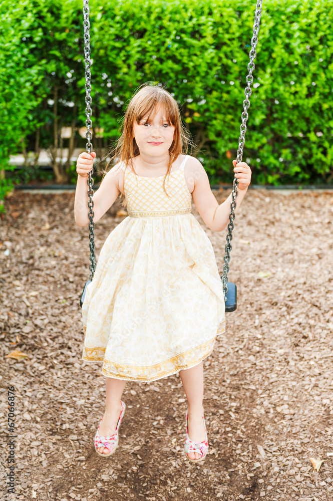 Summer portrait of a cute little girl playing on playground Summer portrait of a cute little girl playing on playground