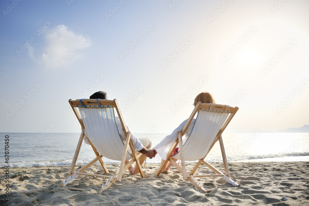 romantic couple on deckchair relaxing on the beach