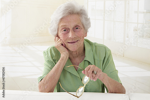 Portrait d'une femme senior tenant ses lunettes photo