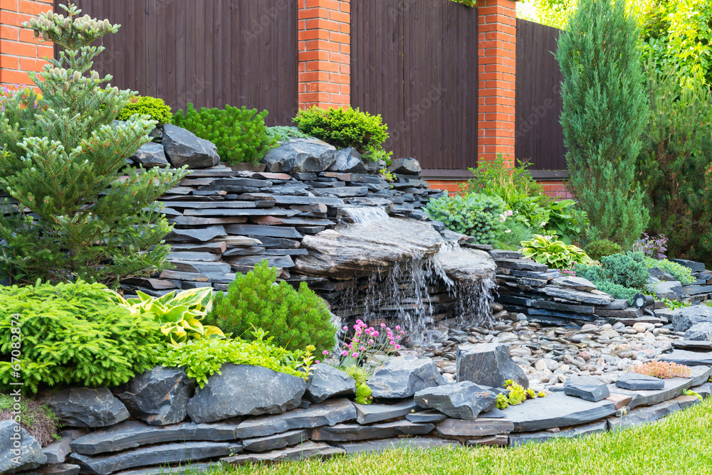 Landscape design in home garden, stones and waterfall in backyard - obrazy, fototapety, plakaty 