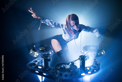 Girl in a nightclub DJ plays on the plates