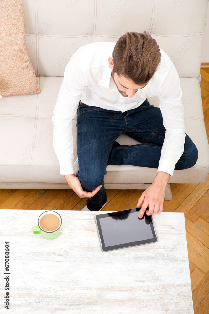 Junger Mann mit Tablet Pc auf dem Sofa Junger Mann mit Tablet Pc auf dem Sofa