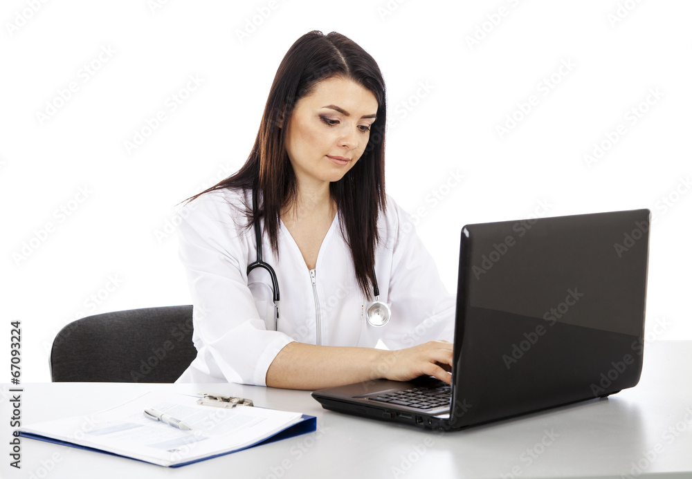 beautiful woman doctor sitting at the table and working on a lap beautiful woman doctor sitting at the table and working on a lap