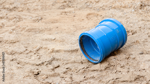 Ein Stück blaues Kunststoffrohr auf einer Sandfläche