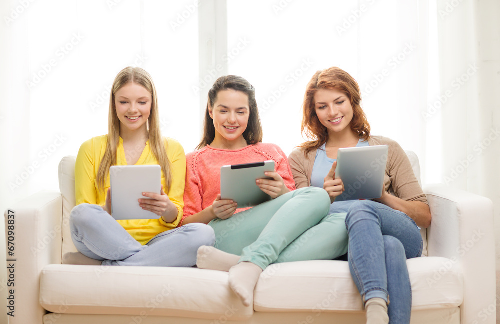 three smiling teenage girls with tablet pc at home three smiling teenage girls with tablet pc at home
