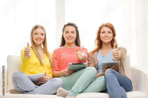 three smiling teenage girls with tablet pc at home © Syda Productions