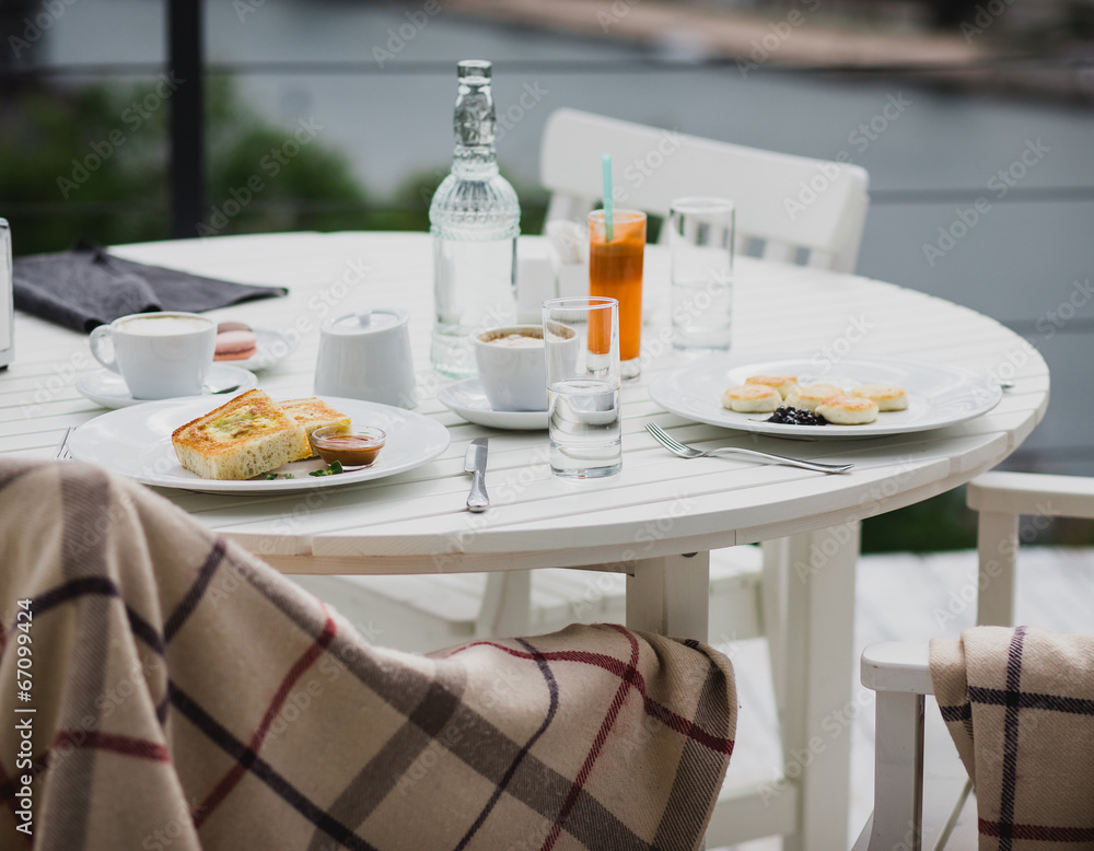 Fototapeta premium breakfast with cheesecakes, toast, cappuccino and macarons