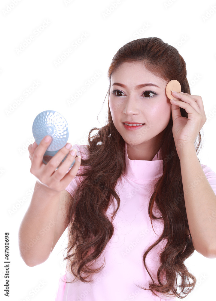 woman looking into the mirror and applying cosmetics woman looking into the mirror and applying cosmetics