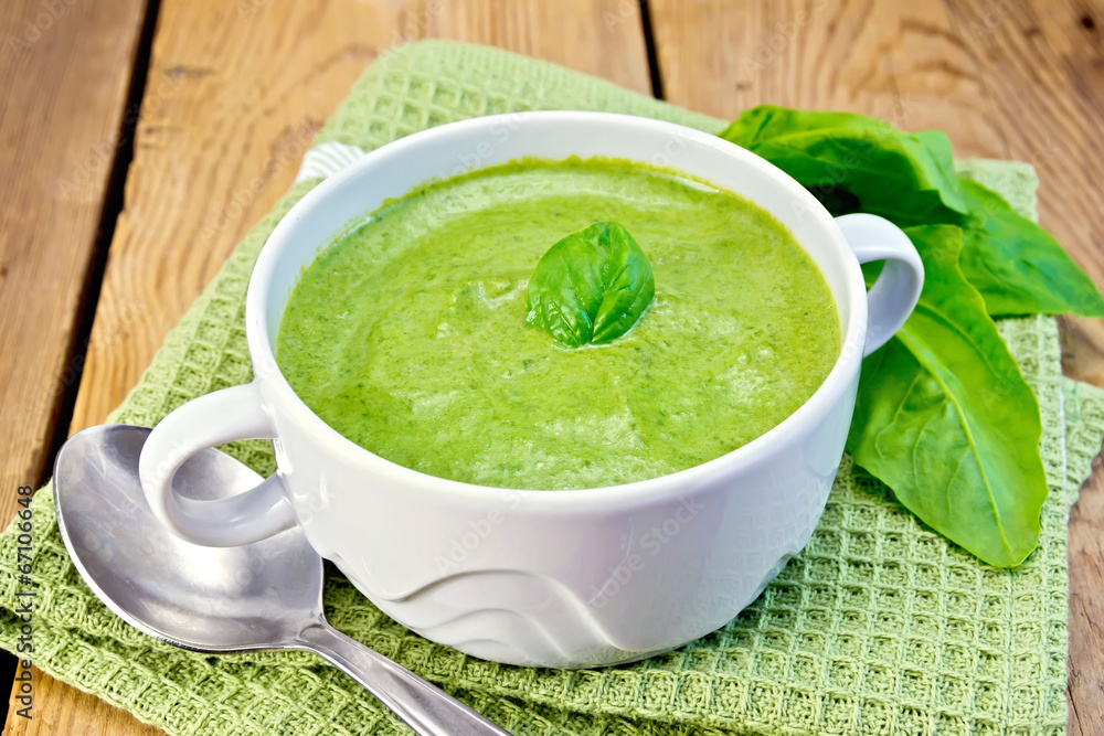 Soup puree with spinach leaves on board Soup puree with spinach leaves on board