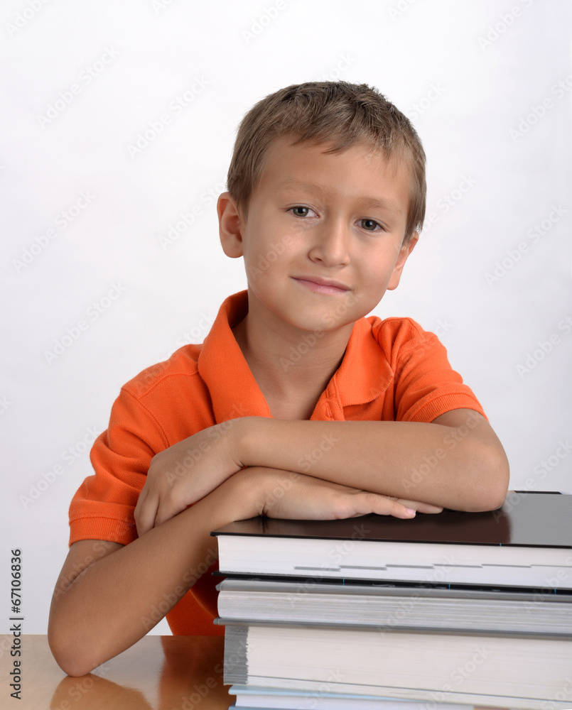 Portrait of a student sitting at a table with a pile of books Portrait of a student sitting at a table with a pile of books