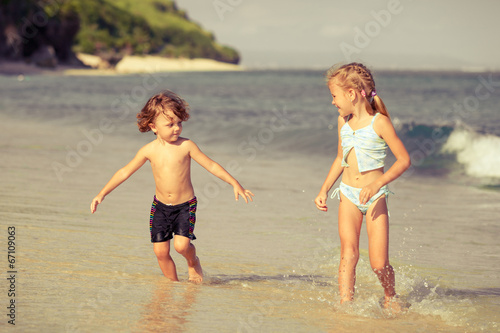 two happy kids playing on beach at the day time