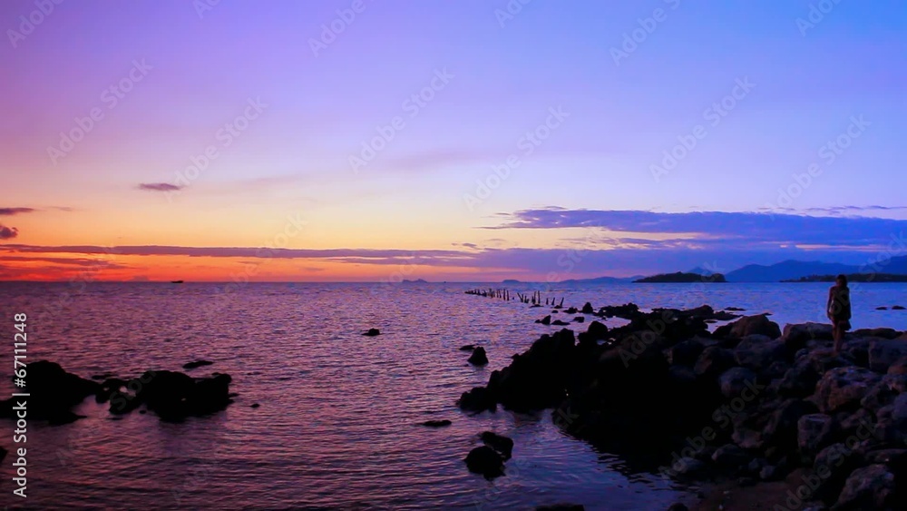 Silhouette of young woman walks on a pile Of stones at the beach Silhouette of young woman walks on a pile Of stones at the beach