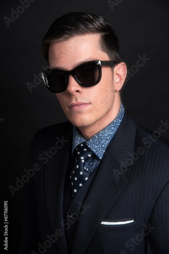 Stylish young business man wearing black retro sunglasses and da