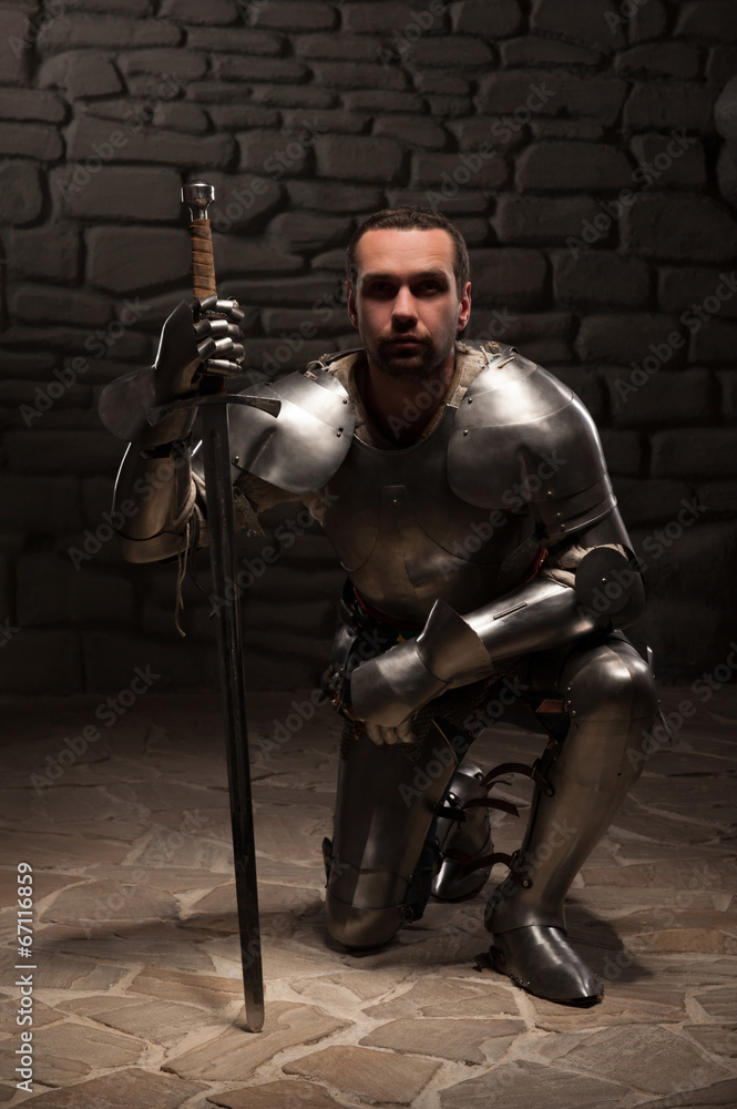 Medieval knight kneeling with sword Stock Photo Adobe Stock
