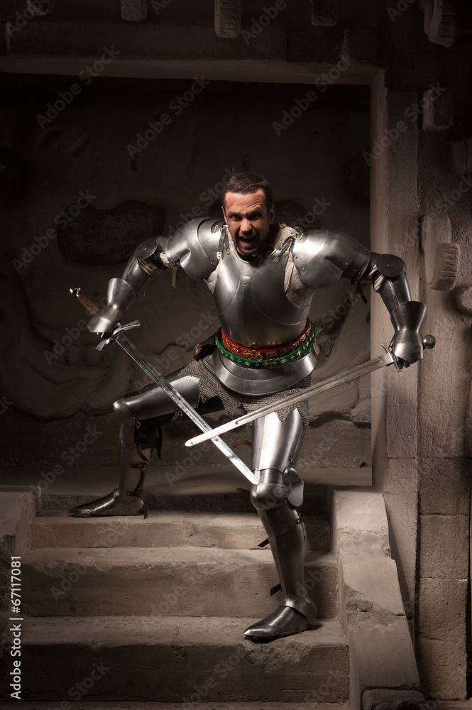 Medieval warrior posing on steps of ancient temple Medieval warrior posing on steps of ancient temple