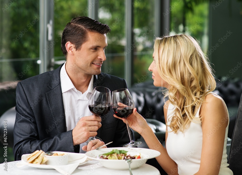 Cheerful couple in a restaurant with glasses of red wine Cheerful couple in a restaurant with glasses of red wine