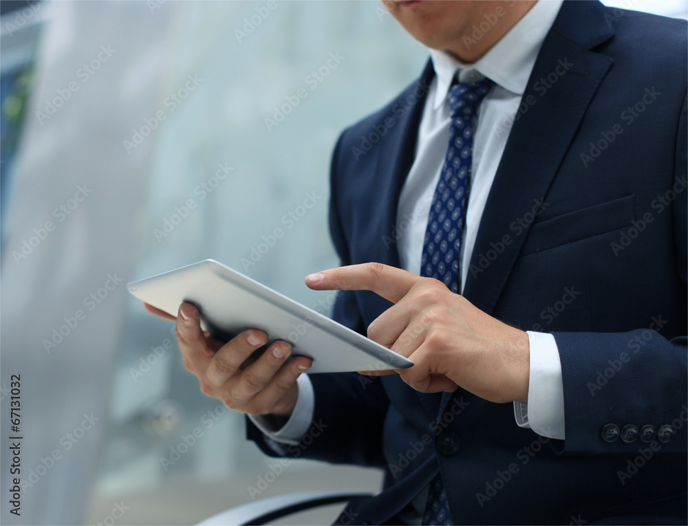 Midsection of businessman using digital tablet in office Midsection of businessman using digital tablet in office