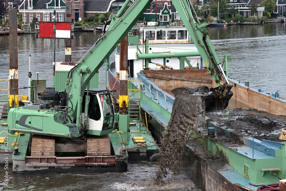 Fototapeta premium Bagger beim Vertiefen der Fahrrinne auf einem Fluss