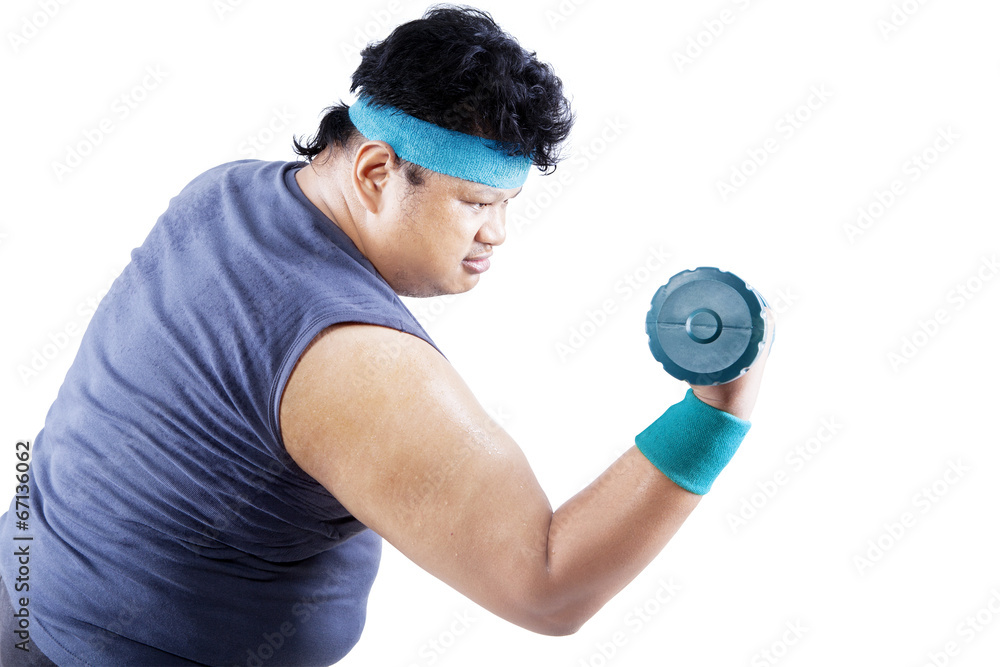 Overweight man exercising with dumbbell 1 Overweight man exercising with dumbbell 1