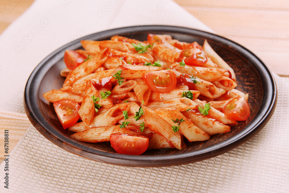 Pasta with tomato sauce on plate on table close-up