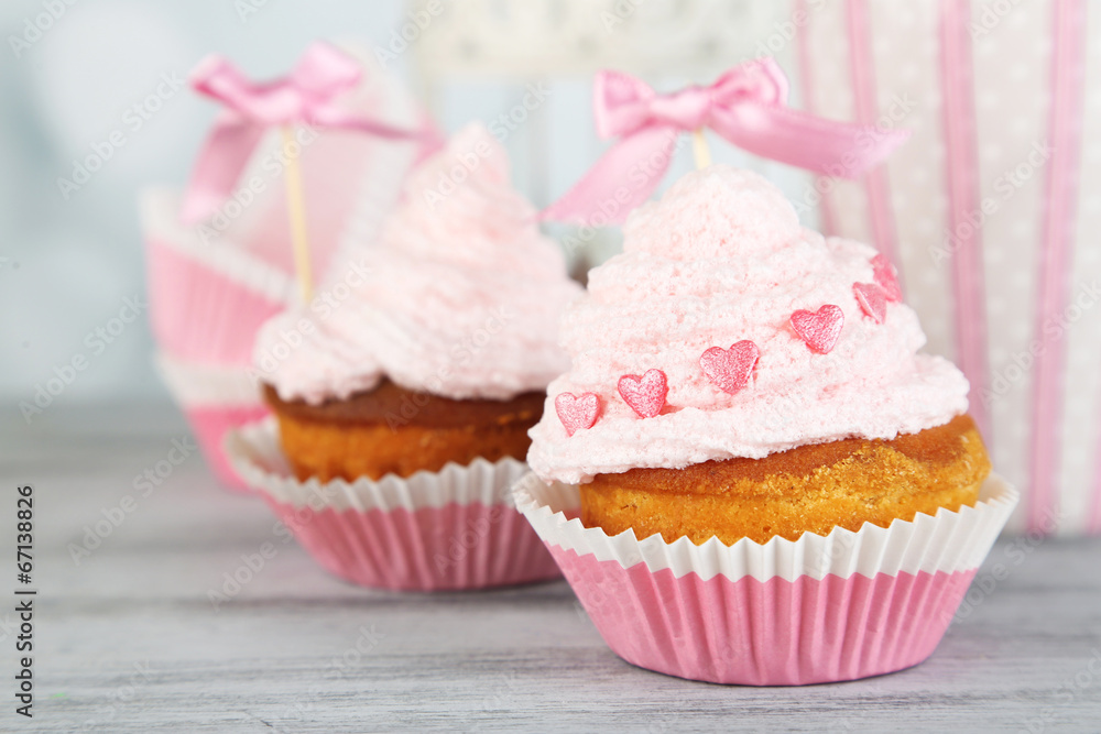 Tasty cup cakes with cream on grey wooden table