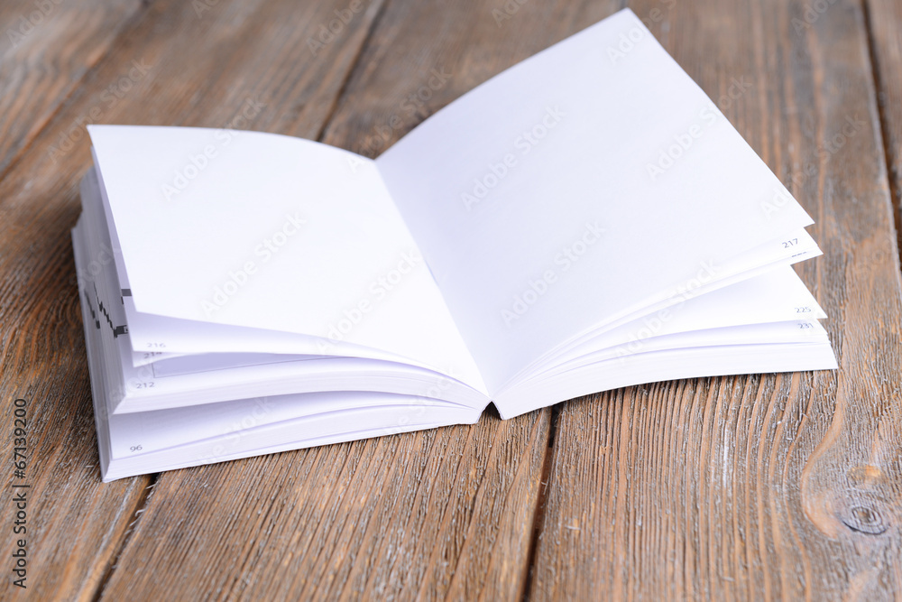 Fototapeta premium Open white book on wooden table, close-up