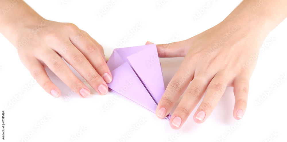 Hands making origami toy, close up, isolated on white Hands making origami toy, close up, isolated on white