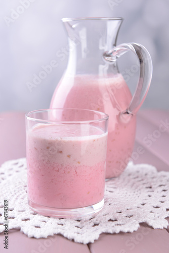 Glass jug of milk cocktail with raspberry taste