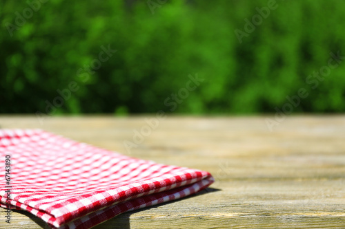 Wooden table with tablecloth, outdoors photo