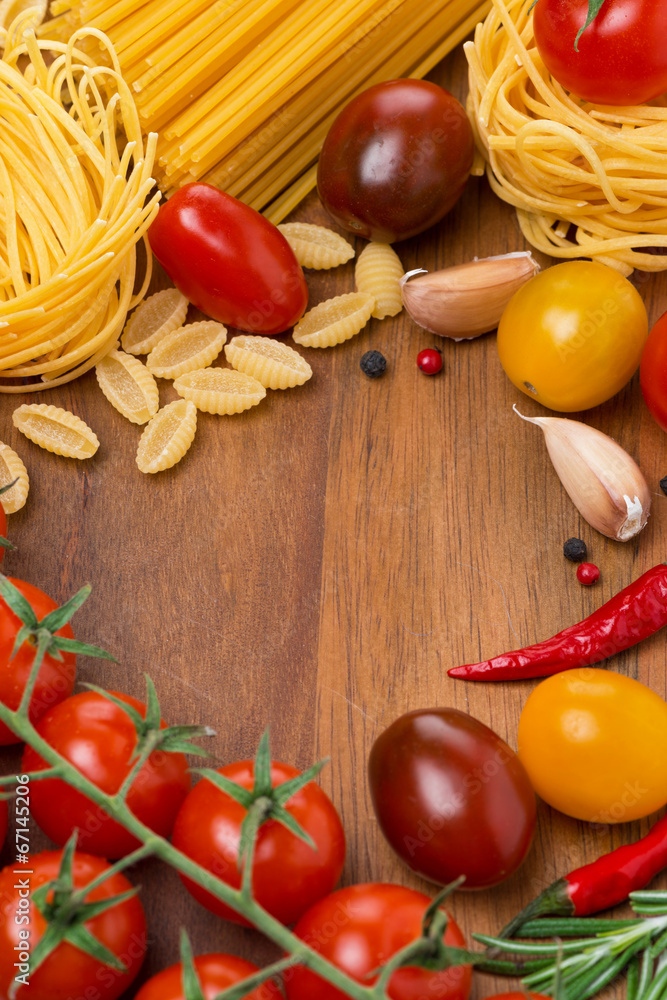 pasta, spices and cherry tomatoes on a wooden board pasta, spices and cherry tomatoes on a wooden board