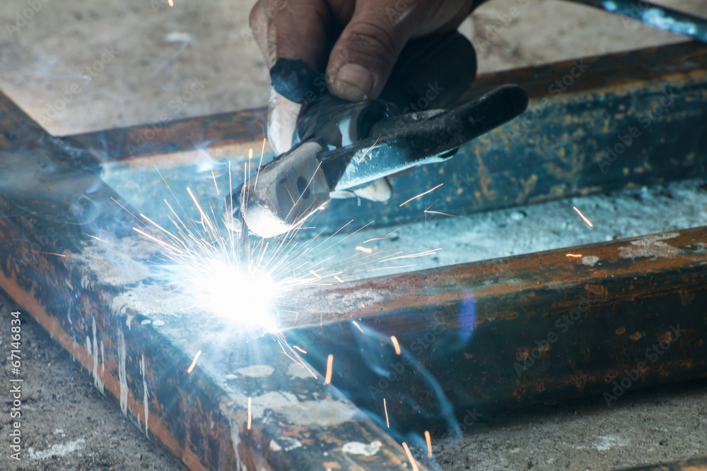Worker welding steel with sparks lighting Worker welding steel with sparks lighting