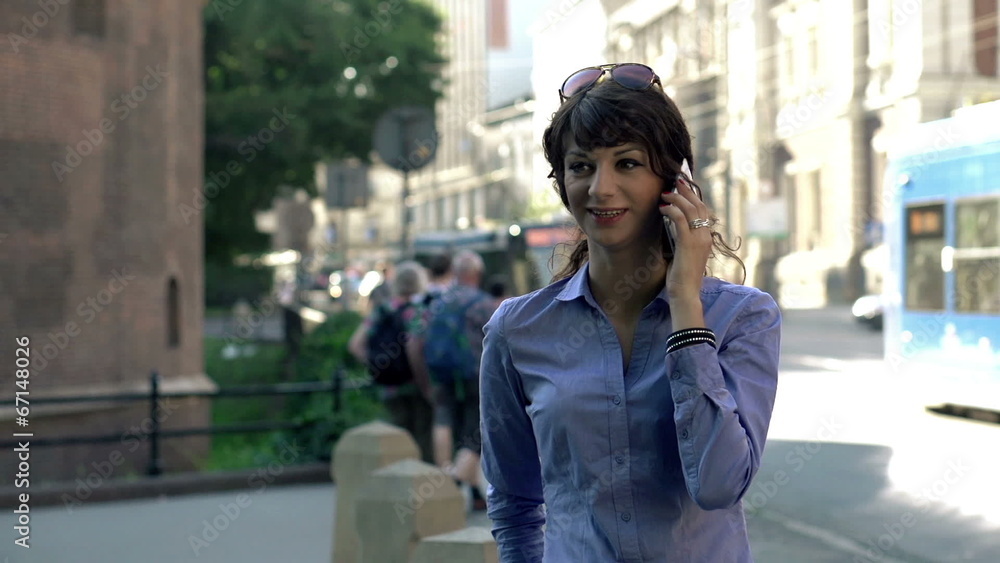 Businesswoman talking on cellphone by the street Businesswoman talking on cellphone by the street