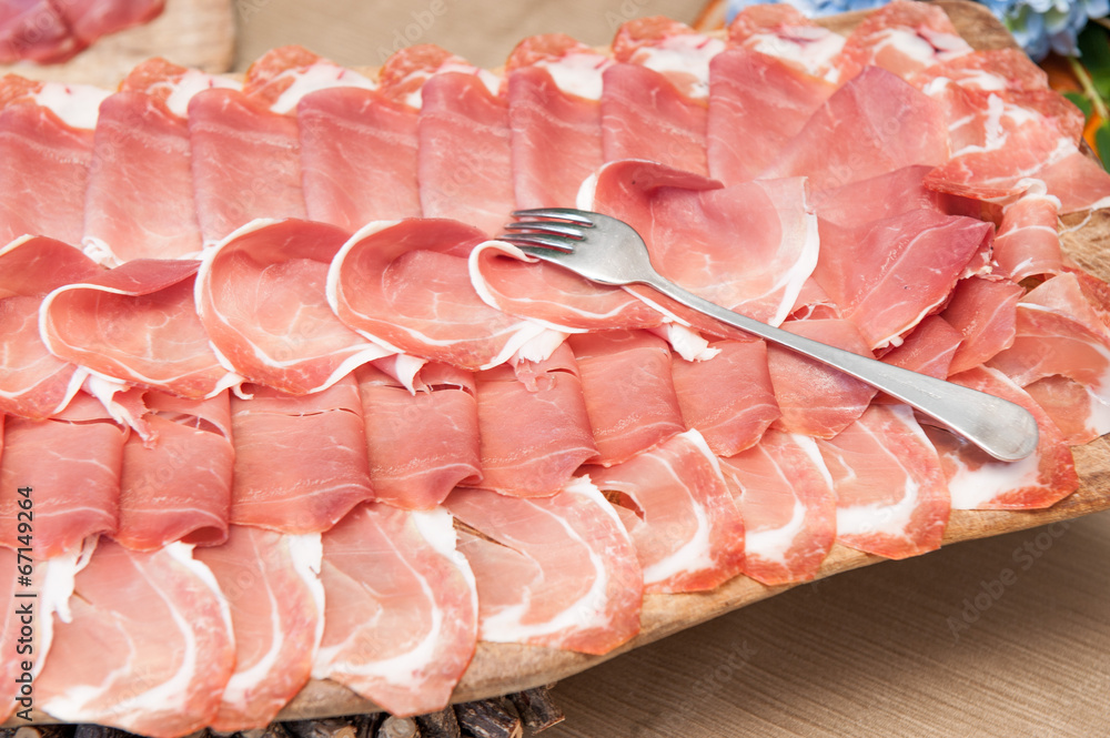 Foto Stock Piatto con fette di prosciutto crudo Adobe Stock