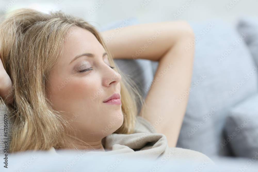 Obraz premium Blond woman in sofa relaxing with eyes shut