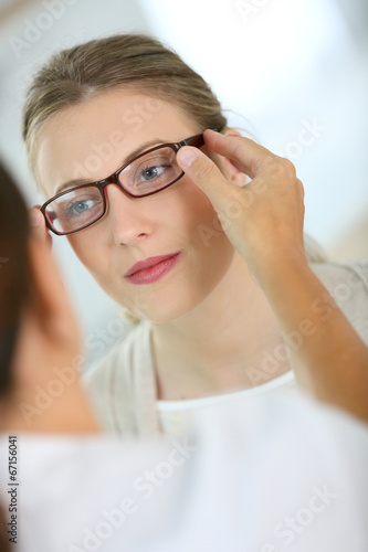 Fototapeta Naklejka Na Ścianę i Meble -  Woman trying new eyeglasses with ophtalmologist