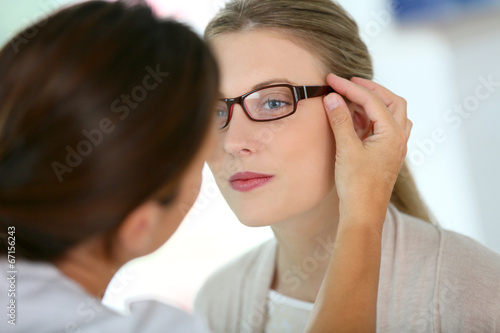 Woman trying new eyeglasses with ophtalmologist photo