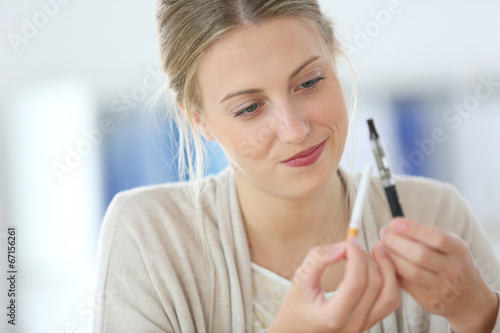 Portrait of young woman ready to opt for e-cigarette