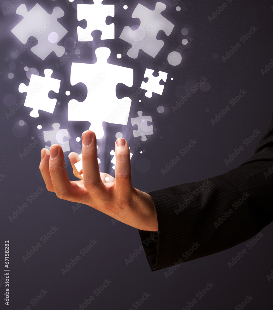 Puzzle pieces in the hand of a businessman Puzzle pieces in the hand of a businessman