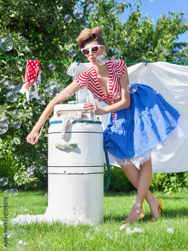 woman doing laundry with vintage wringer washing machine photo