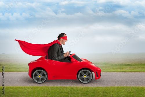 superhero man driving a toy racing car photo