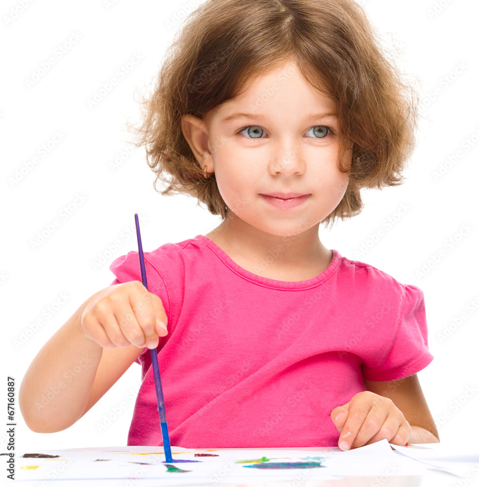 Little girl is painting with gouache