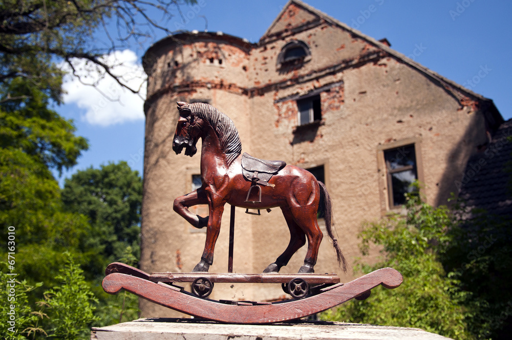 Antikes Schaukelpferd vor historischem Schloss Stock Photo | Adobe Stock