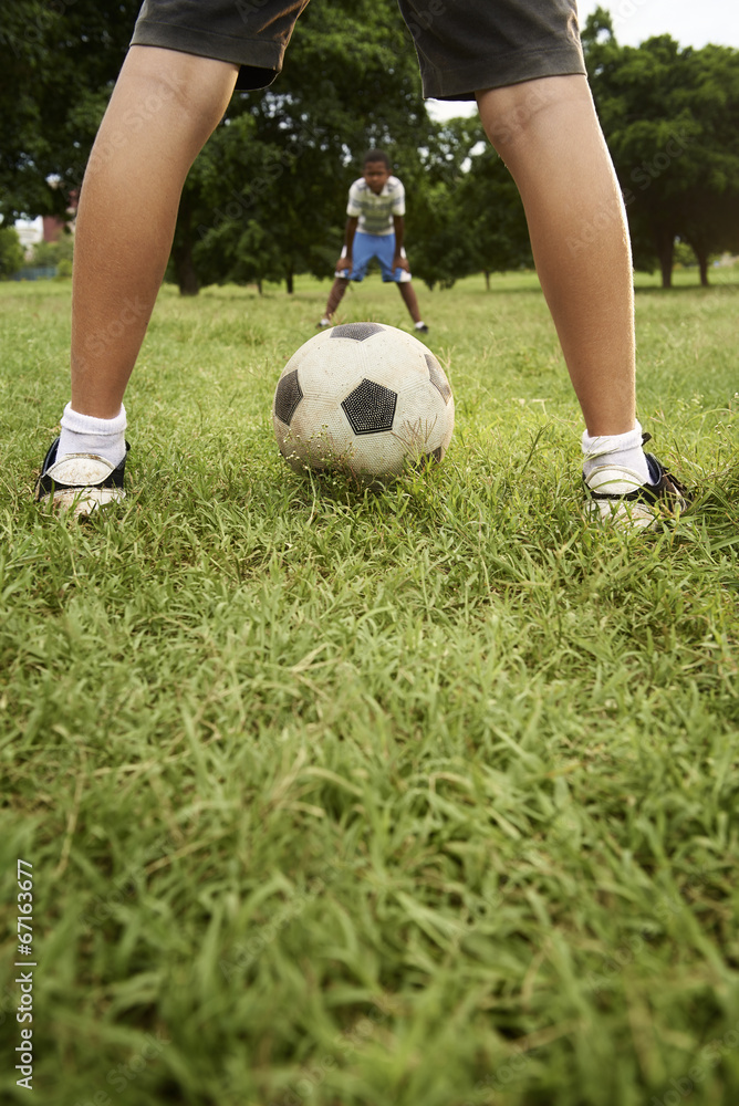 Obraz premium Kids playing football and soccer game in park