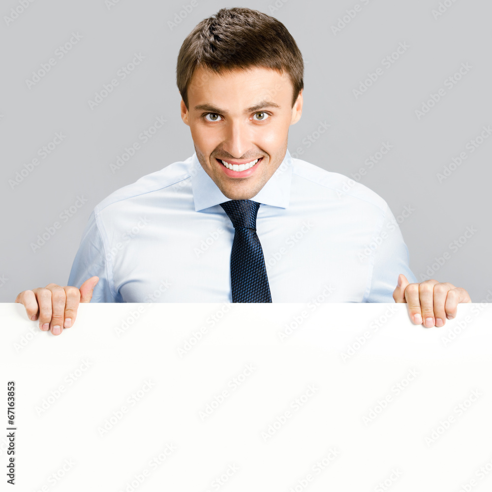 Business man showing blank signboard, over gray Business man showing blank signboard, over gray