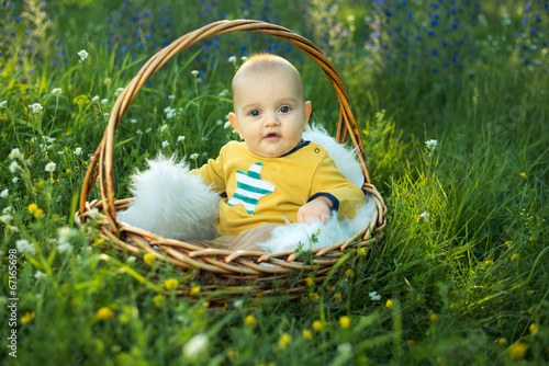 small smiling childin sitting in a basket photo