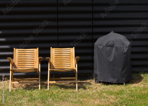 Two chairs and a covered grill