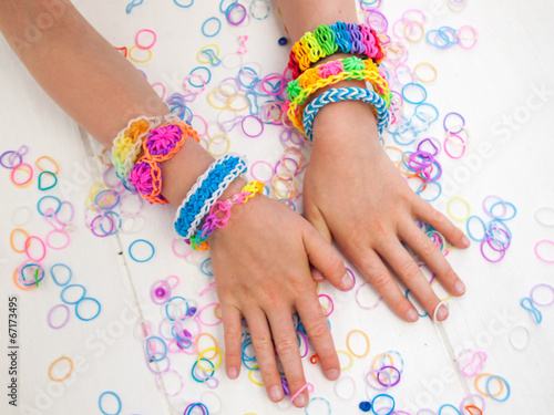 arms of a child wearing multicoloured bracelets