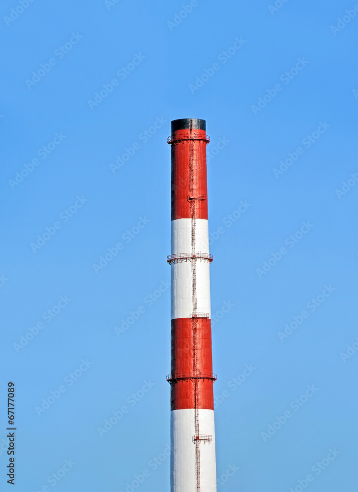 Chimney of industrial plant against blue sky background Chimney of industrial plant against blue sky background