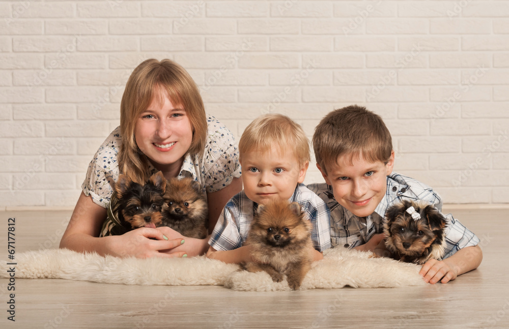 Two little boys and the girl play with little puppies Two little boys and the girl play with little puppies